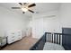 Neutral Bedroom featuring white walls, carpet, a blue crib, changing table and ceiling fan at 9846 Smarty Jones Dr, Ruskin, FL 33573