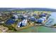 Aerial of waterfront condo complex with boat slips, pool, lake and well-manicured landscaping at 100 Oakmont Ln # 605, Belleair, FL 33756