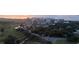 Aerial view of a neighborhood including a golf course at sunset and many buildings at 100 Oakmont Ln # 605, Belleair, FL 33756