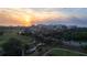 Aerial shot of a sunset over a picturesque neighborhood with golf course, trees, and condominium buildings at 100 Oakmont Ln # 605, Belleair, FL 33756