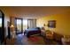 Bright yellow bedroom with a balcony and seating and a cozy sitting area at 100 Oakmont Ln # 605, Belleair, FL 33756