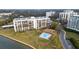Striking exterior view featuring manicured lawn, community pool, and multi-story condominium building at 100 Oakmont Ln # 605, Belleair, FL 33756