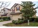 Charming two-story home boasting a two-car garage, red shutters, and mature landscaping at 10262 Newminster Loop, Ruskin, FL 33573