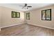Spacious bedroom featuring wood flooring, ceiling fan and bright windows at 104 Anclote Rd # 104, Tarpon Springs, FL 34689