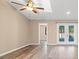 Bright living room featuring wood flooring, ceiling fan and glass doors to the exterior at 104 Anclote Rd # 104, Tarpon Springs, FL 34689