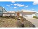 Charming single-story home featuring a white tile roof, front-facing garage, and lovely, low-maintenance landscaping at 10427 Spoonbill W Rd, Bradenton, FL 34209