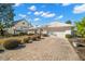 Pretty front exterior of home, showcasing the white tiled roof, brick driveway, and mature landscaping at 10427 Spoonbill W Rd, Bradenton, FL 34209