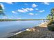 Serene waterfront view with a boat lift and lush greenery under a clear sky at 10427 Spoonbill W Rd, Bradenton, FL 34209