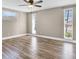 Spacious bedroom featuring wood-look floors, neutral paint, and natural light from multiple windows at 11115 Mckinley Dr, Port Richey, FL 34668