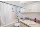 Traditional bathroom featuring a shower-tub combo, white tile, vanity, and a mirrored medicine cabinet at 1118 Excalibur St, Holiday, FL 34690