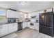 Bright kitchen with white cabinets, stainless steel appliances, and a stylish gray patterned rug at 1118 Excalibur St, Holiday, FL 34690