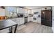 Well-lit kitchen featuring white cabinets, stainless steel appliances, and durable gray laminate flooring at 1118 Excalibur St, Holiday, FL 34690