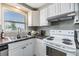 Close up view of a white kitchen, featuring modern appliances, ample countertop space, and natural light at 1118 Excalibur St, Holiday, FL 34690