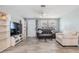 Cozy living room features neutral paint, a ceiling fan, wood-look flooring and bright natural light at 1118 Excalibur St, Holiday, FL 34690