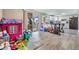 Open concept living room with sliding glass doors, a playful area, and a kitchen view at 1118 Excalibur St, Holiday, FL 34690