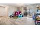 Bright living room with a sliding glass door to the lanai, playroom, and light-colored walls at 1118 Excalibur St, Holiday, FL 34690