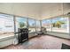 Enclosed sunroom with tile flooring, grill, and views of the surrounding neighborhood at 1118 Excalibur St, Holiday, FL 34690