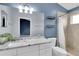 Bathroom featuring a double vanity sink, tiled shower, and storage shelves at 11266 Kapok Grand Cir, Madeira Beach, FL 33708