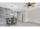 Open dining area featuring a table, chairs, stylish wood accent wall, and ceiling fan at 11266 Kapok Grand Cir, Madeira Beach, FL 33708
