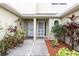 Home entrance with covered porch, landscaping, and concrete walkway at 11266 Kapok Grand Cir, Madeira Beach, FL 33708