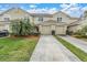 Two-story townhome featuring a two-car garage, well-kept landscaping, and a concrete driveway at 11266 Kapok Grand Cir, Madeira Beach, FL 33708