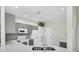 Well-lit kitchen featuring stainless steel appliances, gray cabinets, and tile backsplash at 11266 Kapok Grand Cir, Madeira Beach, FL 33708