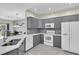 Modern kitchen featuring stainless steel appliances, gray cabinetry, and tile backsplash at 11266 Kapok Grand Cir, Madeira Beach, FL 33708