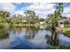 Scenic community pond with a gazebo, mature landscaping, and a tranquil water feature at 11266 Kapok Grand Cir, Madeira Beach, FL 33708