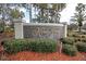 Kapok Grand neighborhood sign surrounded by lush landscaping and mulch at 11266 Kapok Grand Cir, Madeira Beach, FL 33708