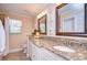 Bathroom with double sink vanity with granite countertop, decorative wall art and mirrors at 11524 River Country Dr, Riverview, FL 33569