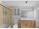 Bathroom featuring a glass shower, updated lighting, vanity, and storage at 1200 N Shore Ne Dr # 102, St Petersburg, FL 33701