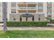 Exterior daytime view of the Shore Crest condominium building entrance with stone trim, and green foliage at 1200 N Shore Ne Dr # 102, St Petersburg, FL 33701