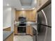 Stainless steel appliances complement the tile backsplash and light wood cabinetry in this kitchen at 1200 N Shore Ne Dr # 102, St Petersburg, FL 33701