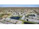 Wide aerial view of community featuring manicured landscaping, a pond, and well-maintained buildings at 12709 Raeburn Way, Tampa, FL 33624