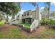 A spacious backyard showing the building's stucco construction, a small artificial lawn area, and some natural landscaping at 13502 Palmwood Ln # 13502, Tampa, FL 33618