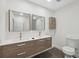 Modern bath featuring double sinks, wood cabinets, decorative mirrors and updated fixtures at 13502 Palmwood Ln # 13502, Tampa, FL 33618