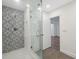 Tastefully renovated bathroom showcases a stylish shower with patterned tile accent wall and a glass door at 13502 Palmwood Ln # 13502, Tampa, FL 33618