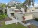 View of townhome's exterior, including its driveway, garage, walkway, and verdant landscaping at 13502 Palmwood Ln # 13502, Tampa, FL 33618