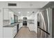 Modern kitchen with stainless steel appliances and sleek white cabinets and backsplash at 13502 Palmwood Ln # 13502, Tampa, FL 33618