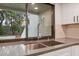 Double sink with gray countertop, modern faucet, herringbone backsplash and views to the backyard at 13502 Palmwood Ln # 13502, Tampa, FL 33618