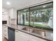 Modern kitchen sink with gray countertops, white cabinetry and a large window overlooking the yard at 13502 Palmwood Ln # 13502, Tampa, FL 33618