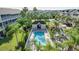 Community pool surrounded by lush landscaping, sun loungers, and a small clubhouse at 14 Seagrape Cir, Clearwater, FL 33759