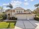 Charming two-story home boasts a spacious three-car garage, tile roof, and well-manicured landscaping with palms at 18014 Forest Retreat Ln, Tampa, FL 33647