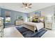 Comfortable main bedroom with a king bed, blue accent wall, and two windows for natural light at 18014 Forest Retreat Ln, Tampa, FL 33647