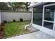 Landscaped backyard with green grass, flower beds, and a screened-in porch at 19432 Haskell Pl, Land O Lakes, FL 34638