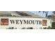 Weymouth community sign with decorative tree graphics and well-maintained landscaping at 19432 Haskell Pl, Land O Lakes, FL 34638