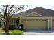 Inviting front exterior showing attached garage, well-manicured lawn, and mature landscaping at 19432 Haskell Pl, Land O Lakes, FL 34638