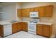 Well-lit kitchen with light-colored cabinets and appliances, paired with white countertops and tiled floors at 19432 Haskell Pl, Land O Lakes, FL 34638