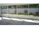 Enclosed, screened porch with concrete flooring and view of a manicured backyard at 19432 Haskell Pl, Land O Lakes, FL 34638