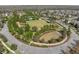 Aerial shot of a park in a housing community featuring an open field, pool, playground, and mature trees at 2845 Murray Pass, Odessa, FL 33556